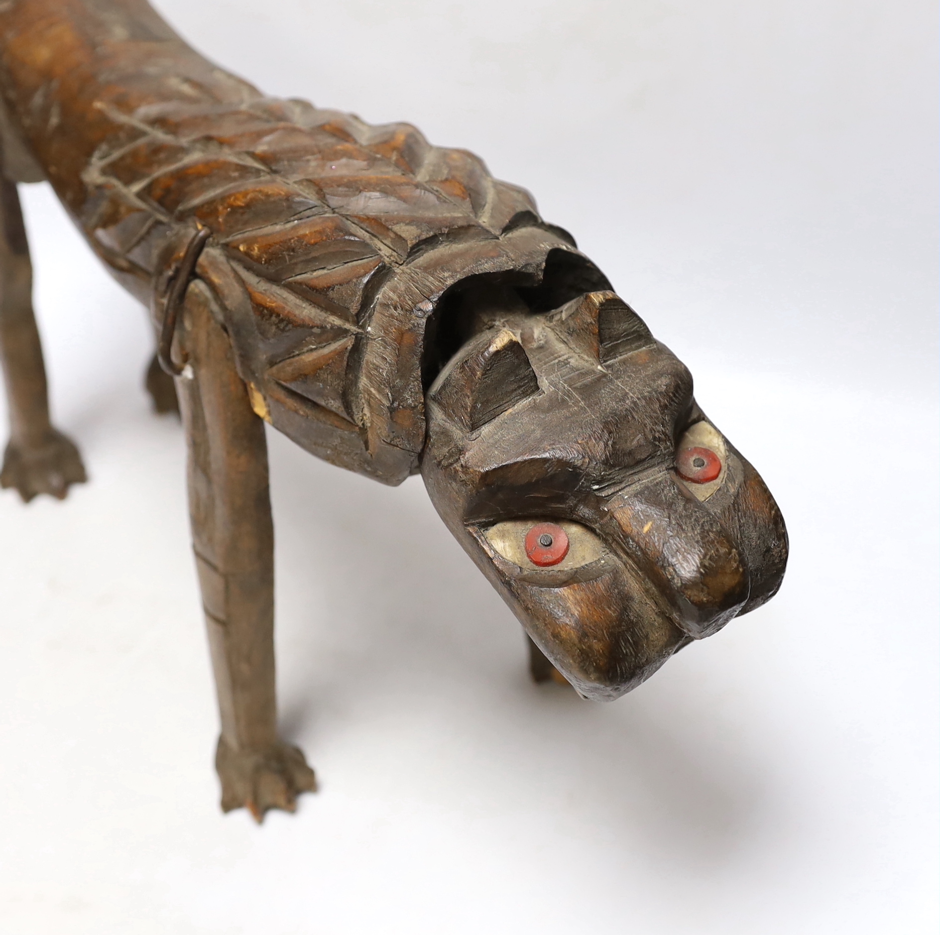 An primitive African articulated wood model of a lion, 41cm wide